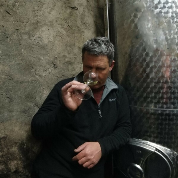 Weingut August Perll © Weingut August Perll Winzer Thomas Perll steht in seinem Weinkeller und riecht an einem Glas Wein © Weingut August Perll