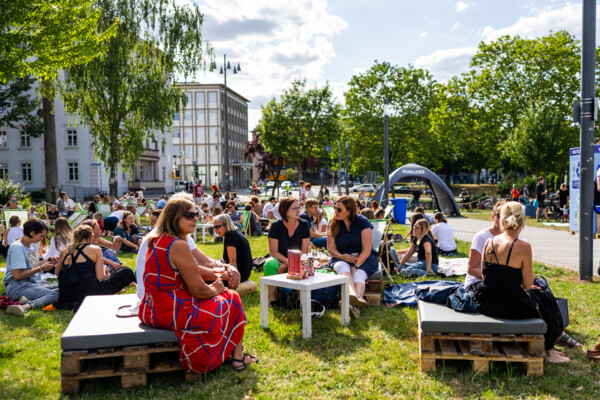Personen sitzen bei der Blauen Stunde an der Rhein-Mosel-Halle in Koblenz © Koblenz-Touristik GmbH, Kai Myller Personen sitzen bei der Blauen Stunde an der Rhein-Mosel-Halle in Koblenz © Koblenz-Touristik GmbH, Kai Myller